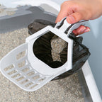 Litter scoop with a waste bag clipped underneath, scooping a litter tray