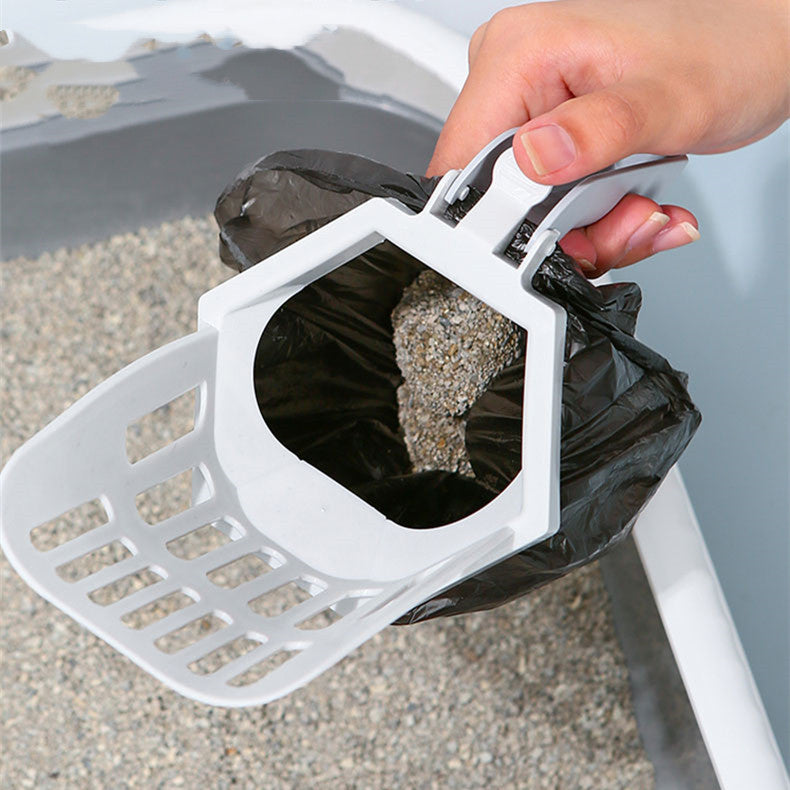 Litter scoop with a waste bag clipped underneath, scooping a litter tray