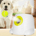 Golden retriever puppy with a mini tennis ball beside the automatic ball launcher